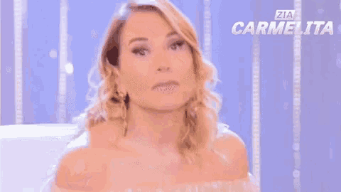a woman blowing a kiss in front of a sign that says zia carmelita