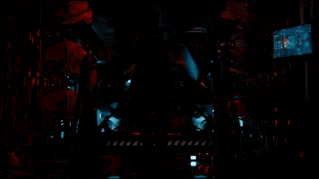a man is standing in a room with a robot and a monitor