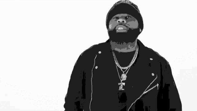 a black and white photo of a man with a beard wearing a beanie and a jacket