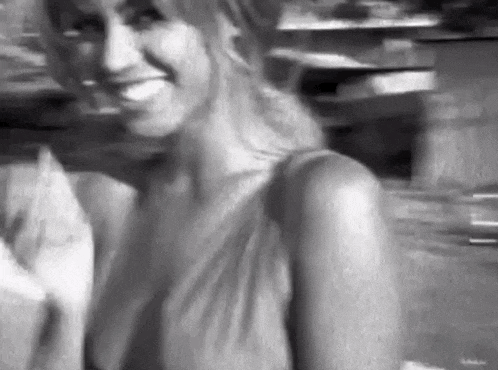 a black and white photo of a woman smiling in a black and white photo .