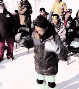 a group of people are standing in the snow and one of them is wearing a jacket that says ' salomon ' on the back
