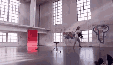 a person is dancing in an empty room with graffiti on the walls