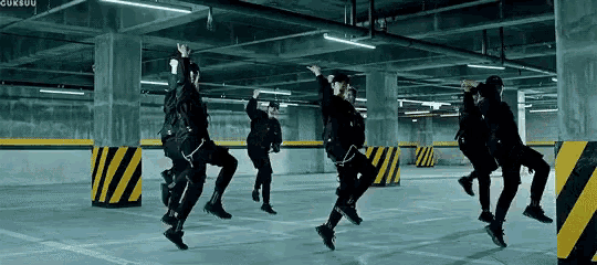 a group of people are jumping in the air in a parking lot .