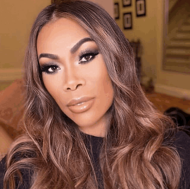 a woman with long brown hair is wearing a black sweater