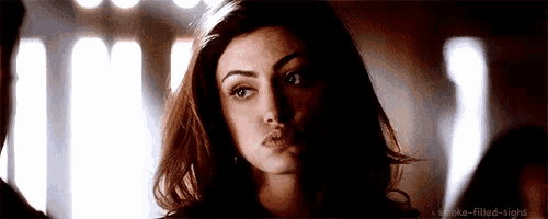 a close up of a woman 's face looking at the camera with a serious look on her face .