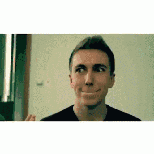 a man is making a funny face while looking at himself in a mirror .