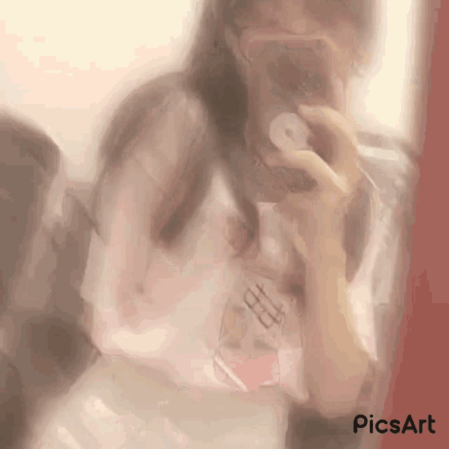 a blurry picture of a girl taking a selfie with a phone