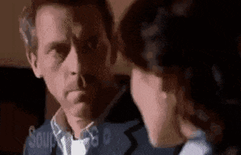 a man and a woman are looking at each other . the woman is touching the man 's face .