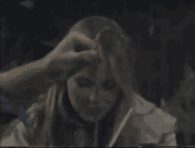 a man is putting a cigarette in a woman 's mouth in a dark room .