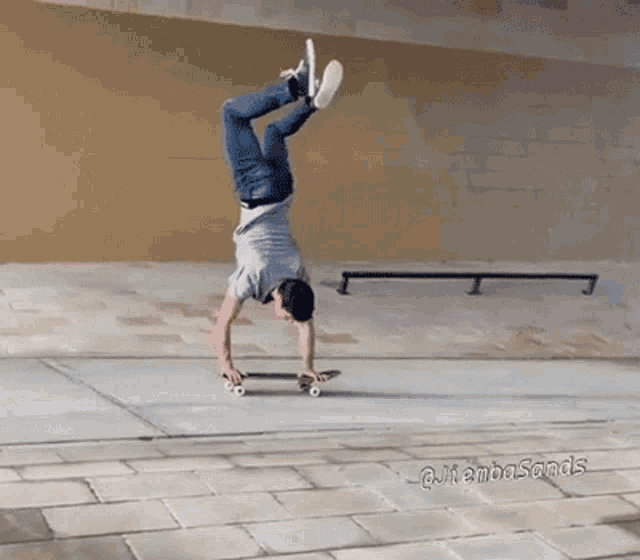 a man is doing a handstand on a skateboard in front of a sign that says @jambasands