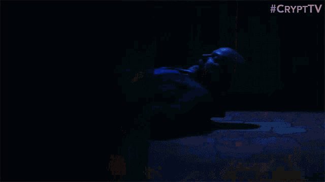 a man is laying on the floor in a kitchen with a crypt tv logo behind him