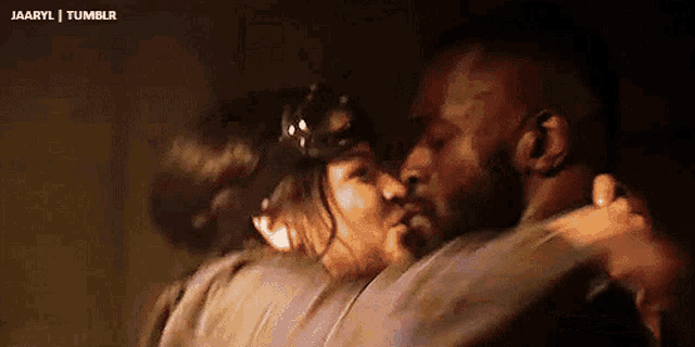 a man and a woman are hugging and kissing each other .