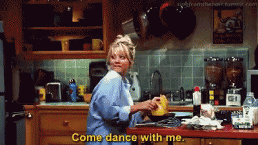 a woman is standing in a kitchen with the words come dance with me