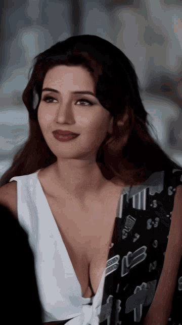 a woman with a plunging neckline is wearing a black and white shirt with the letter e on it