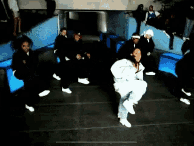 a group of people are dancing in a dark room with blue lights