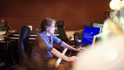 a man sitting at a desk with a blue screen that says ' error ' on it