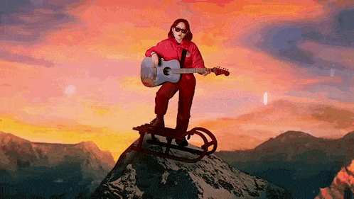 a person playing a guitar while standing on a sled