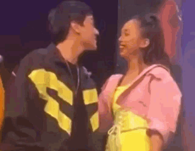 a man and a woman are looking at each other .