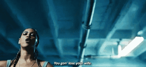 a woman is singing in a dark room and saying `` you gon lose your wife '' .
