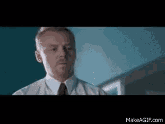 a man in a white shirt and red tie is standing in a room .