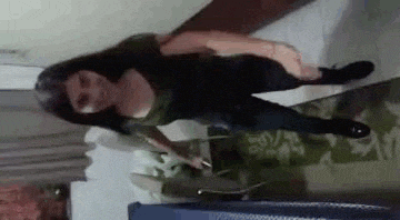 a woman is standing on a couch in a room .