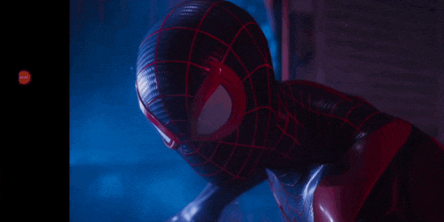 a close up of a spiderman 's face with a red eye