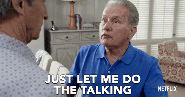 a man in a blue shirt says " just let me do the talking " while talking to another man