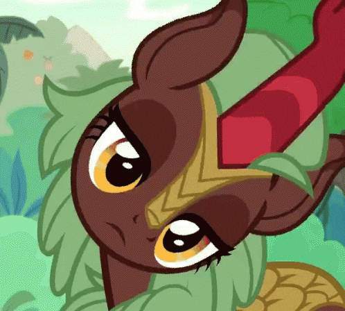 a close up of a cartoon pony with green hair and a red horn