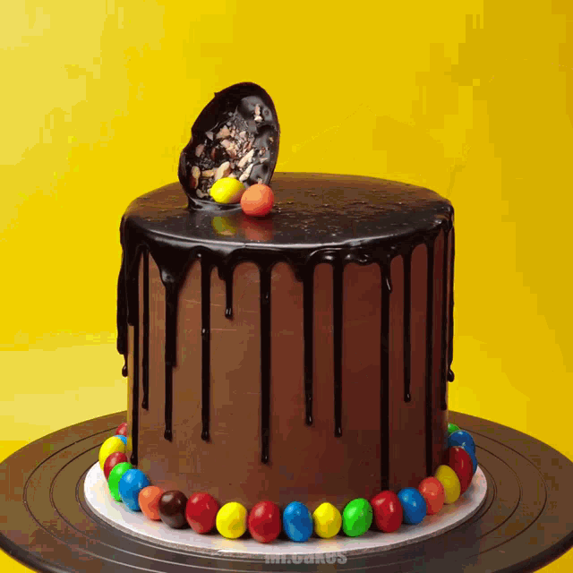 a chocolate cake with dripping chocolate and m & m 's