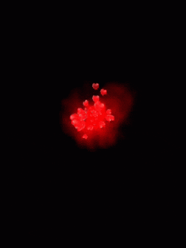 a bunch of red hearts are floating in the air on a dark background