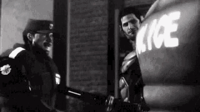 a black and white photo of two men standing next to each other .