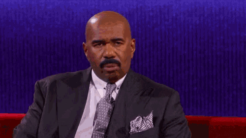 a man in a suit and tie is sitting on a couch