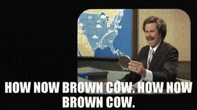 a man in a suit and tie is standing in front of a map with the words " now now brown cow " on the bottom
