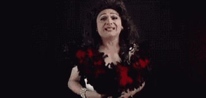 a woman in a wig is making a funny face in front of the words te jodis te .