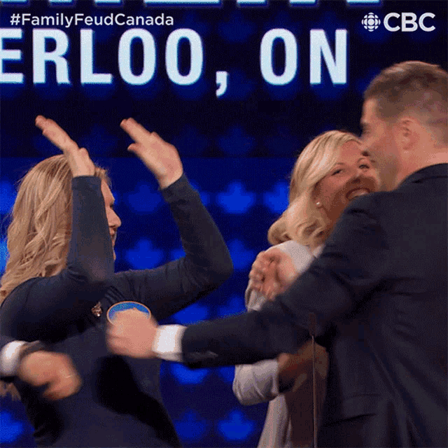 a group of people are hugging in front of a sign that says erloo on