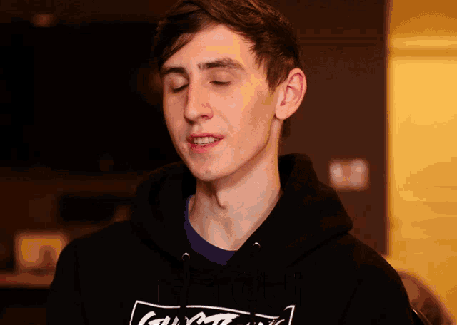 a young man wearing a black hoodie with the word calvin klein on the front
