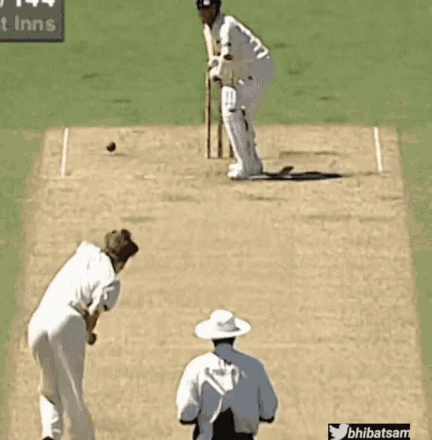 a cricket player is getting ready to hit a ball with a green sign in the background that says ' t inns '