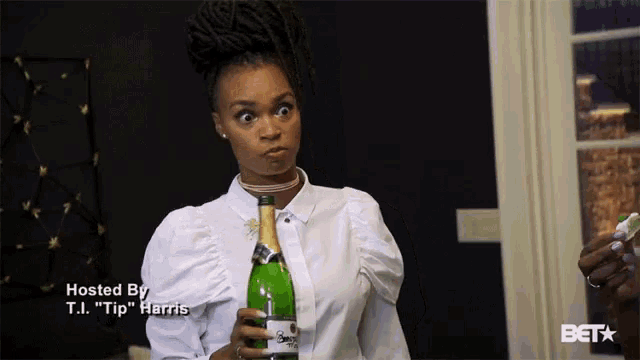 a woman in a white shirt is holding a bottle of champagne