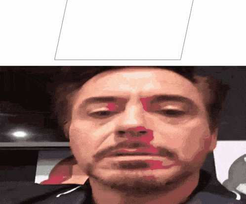 a close up of a man 's face with a red spot on it
