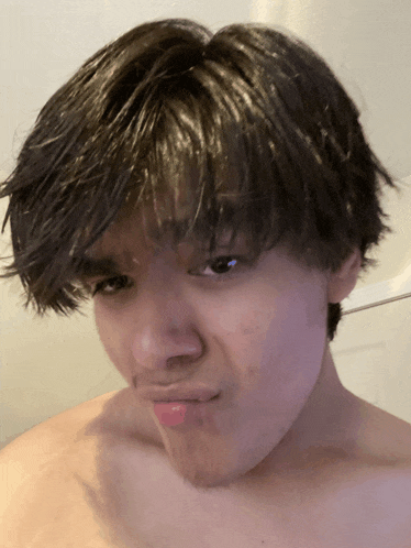 a young man without a shirt is making a face
