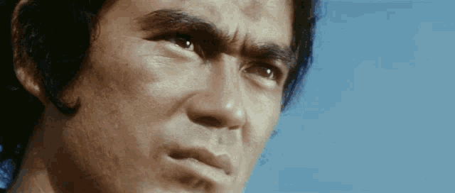 a close up of a man 's face with a blue background