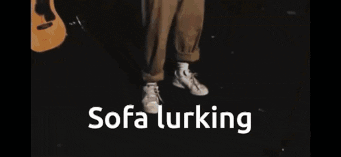 a man standing in a dark room with the words " sofa lurking " on the screen