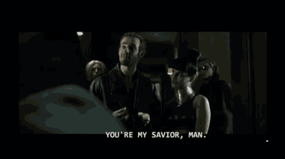 a man and a woman are standing next to each other in a dark room and the man says " my own personal jesus christ "