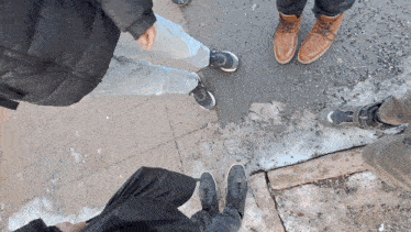 a group of people standing on a sidewalk wearing different shoes