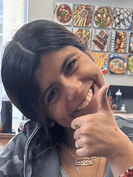 a woman is smiling and giving a thumbs up in front of a wall of food images