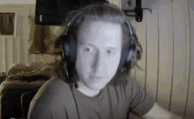 a man wearing headphones and a microphone is sitting in front of a computer .