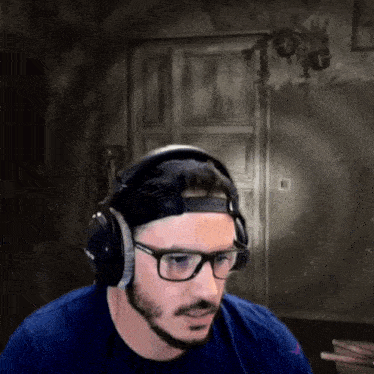 a man with a beard wearing headphones and glasses .