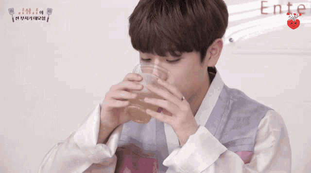 a young man drinking from a plastic cup with the word enter written on the bottom