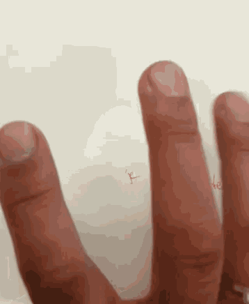 a close up of a person 's hand with a red x on the thumb
