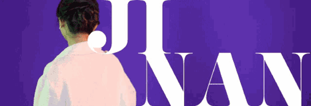 a woman stands in front of a purple background that says j nan on it